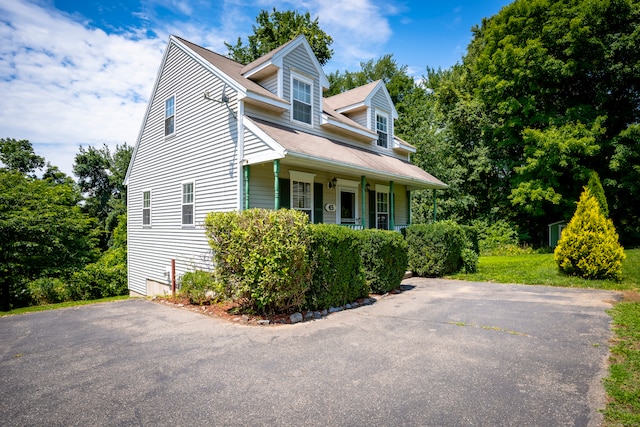 view of side of property featuring covered porch