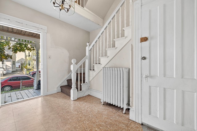 entryway with radiator and an inviting chandelier