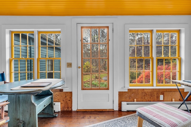 doorway with wood finished floors, a baseboard radiator, baseboard heating, wainscoting, and wood ceiling