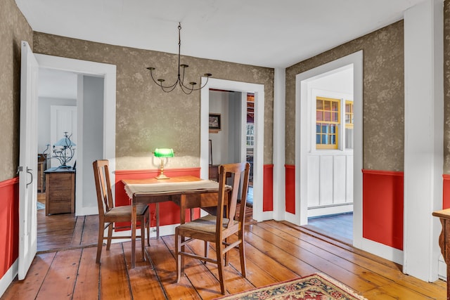 dining room featuring a chandelier, a baseboard radiator, and hardwood / wood-style floors