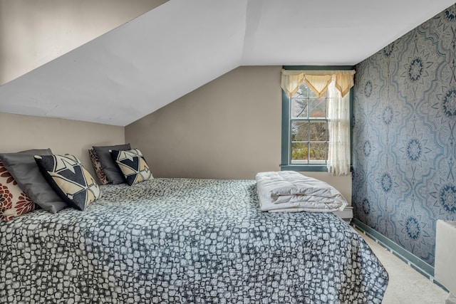 bedroom with lofted ceiling, carpet flooring, and baseboards