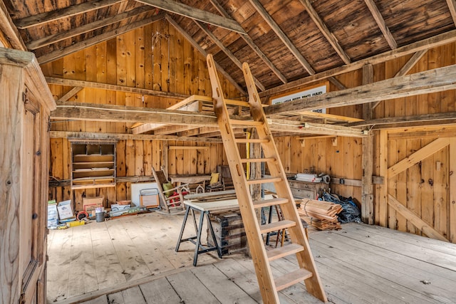 misc room featuring wooden walls, lofted ceiling, and hardwood / wood-style flooring