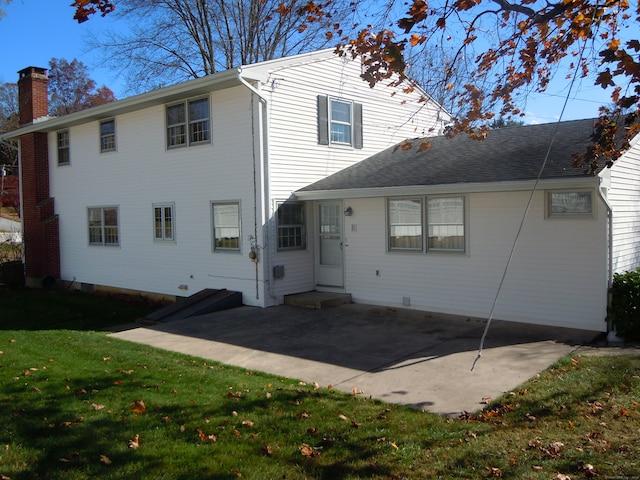 rear view of property with a lawn and a patio