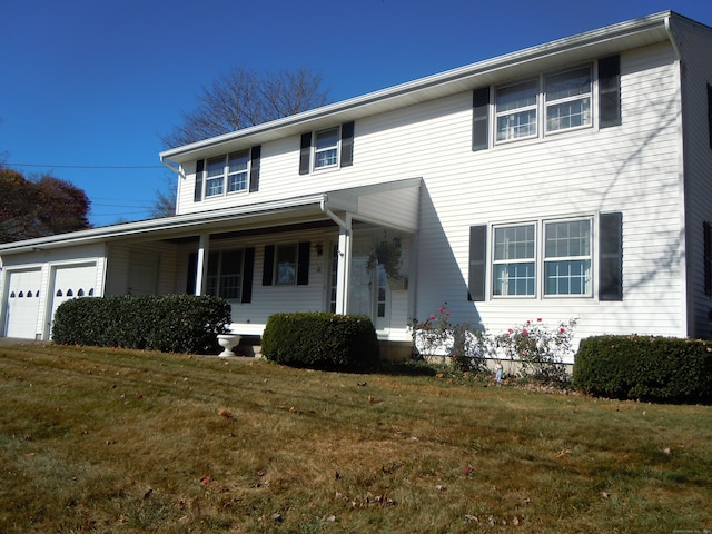 view of front facade with a front lawn, covered porch, and a garage