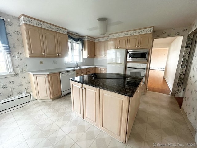 kitchen featuring light brown cabinets, a center island, white appliances, and sink