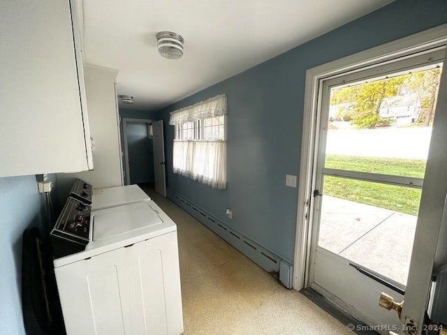 clothes washing area with cabinets, a baseboard radiator, and washer and clothes dryer