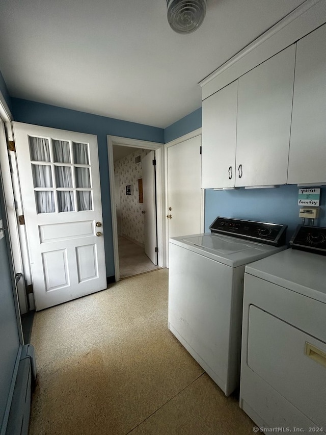 washroom with washer and dryer and cabinets