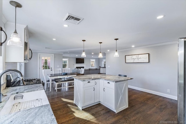 kitchen featuring white cabinetry, hanging light fixtures, a kitchen island, and dark wood-type flooring