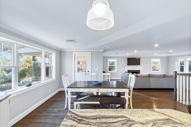 dining room featuring dark hardwood / wood-style flooring, ornamental molding, and a wealth of natural light