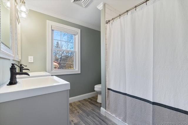 bathroom with toilet, hardwood / wood-style floors, vanity, and ornamental molding