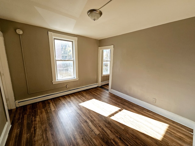 unfurnished room with baseboard heating and dark hardwood / wood-style flooring