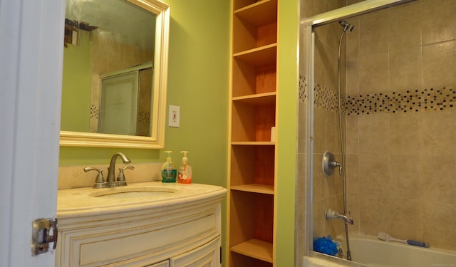 bathroom with built in shelves, vanity, and tiled shower / bath