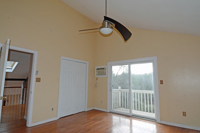 unfurnished bedroom with access to outside, a wall mounted AC, ceiling fan, a closet, and light hardwood / wood-style flooring