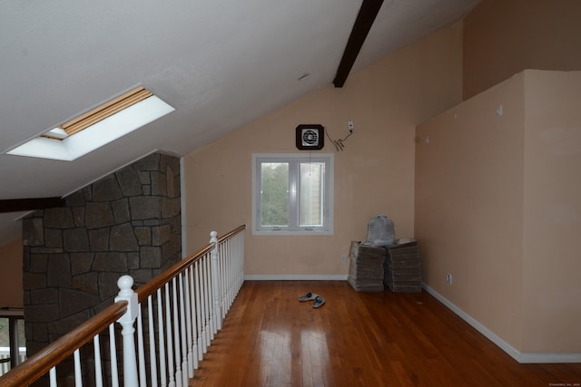 bonus room with hardwood / wood-style flooring and vaulted ceiling with skylight