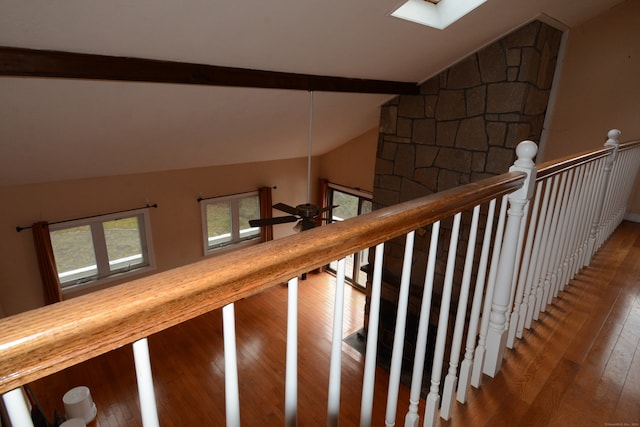 stairs with hardwood / wood-style floors and lofted ceiling with skylight