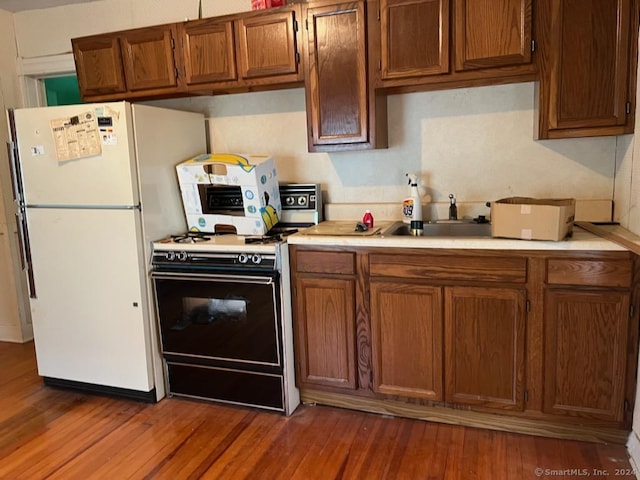 kitchen with white fridge, range, and dark wood-type flooring