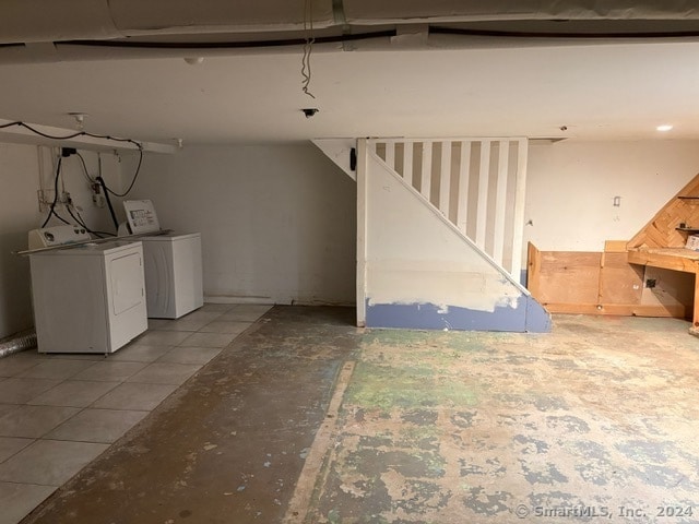 basement featuring washing machine and dryer and light tile patterned floors