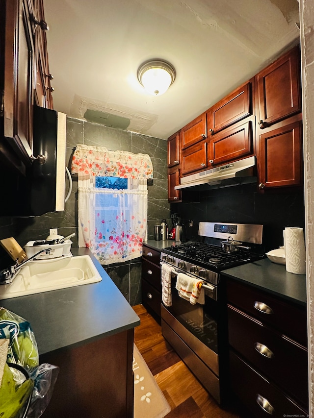 kitchen with sink, dark wood-type flooring, backsplash, and stainless steel range with gas stovetop