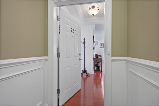 corridor with ornamental molding and wood-type flooring