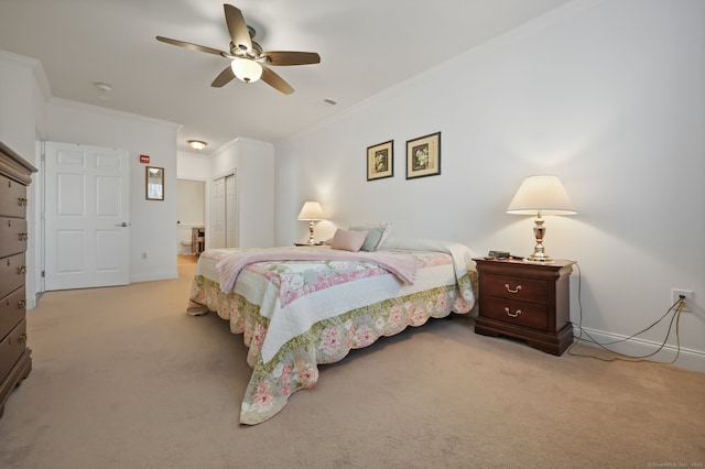 carpeted bedroom featuring ceiling fan, connected bathroom, a closet, and ornamental molding