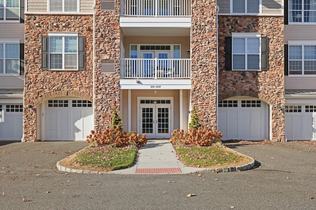 exterior space featuring a garage, french doors, and a balcony