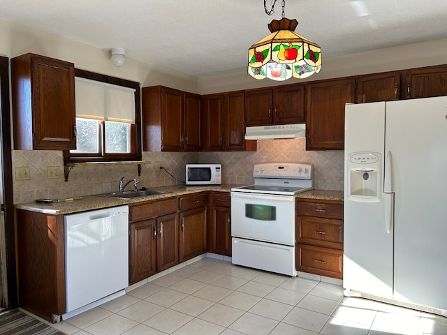 kitchen featuring hanging light fixtures, sink, light tile patterned floors, light stone counters, and white appliances