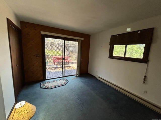 carpeted empty room featuring a baseboard radiator