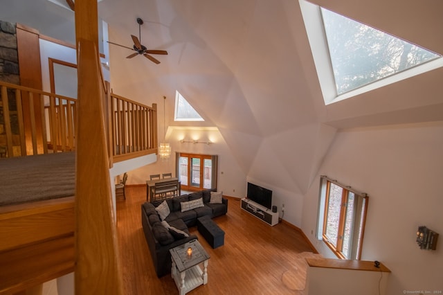 living room with light wood-type flooring, a skylight, and a healthy amount of sunlight