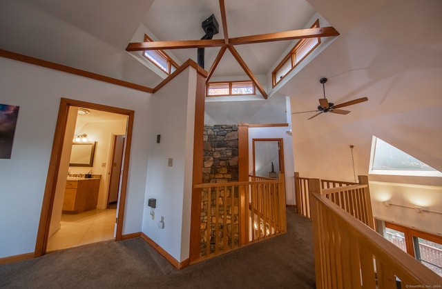 hall with carpet flooring, a towering ceiling, and a wealth of natural light