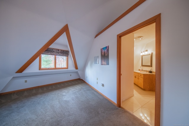 bonus room with light colored carpet, sink, and vaulted ceiling