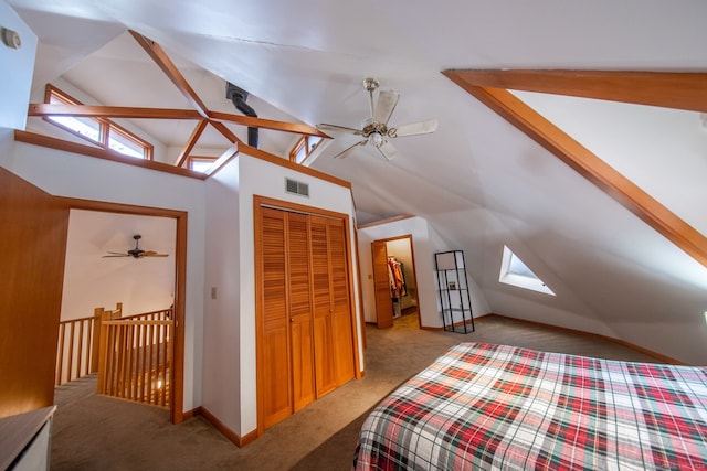 bedroom featuring light colored carpet, ceiling fan, vaulted ceiling with skylight, and a closet