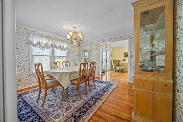 dining area with a chandelier, light hardwood / wood-style floors, and ornamental molding