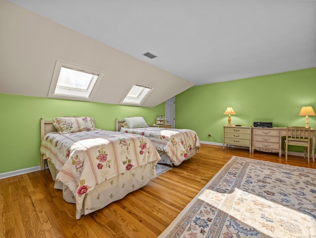 bedroom with hardwood / wood-style floors and vaulted ceiling