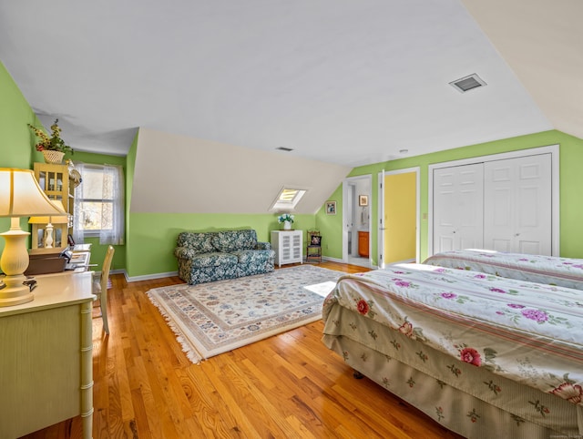 bedroom featuring light hardwood / wood-style floors, a closet, and lofted ceiling