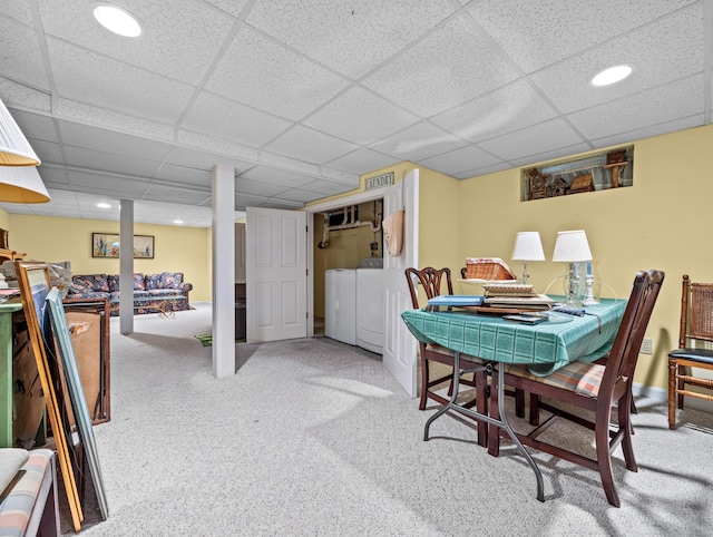 carpeted dining area featuring a paneled ceiling and washing machine and dryer