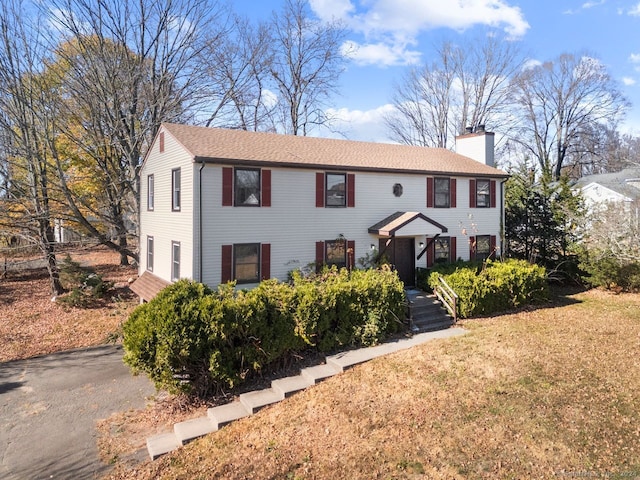 colonial house featuring a front lawn