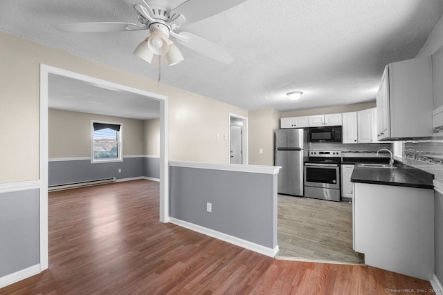 kitchen with stainless steel appliances, sink, backsplash, light hardwood / wood-style flooring, and white cabinets