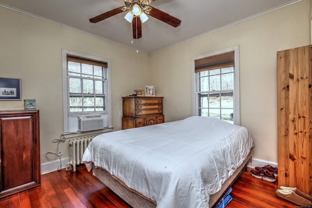 bedroom with cooling unit, dark wood-type flooring, radiator, ceiling fan, and crown molding