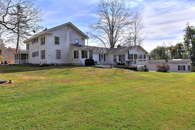 back of property with a lawn and a wooden deck