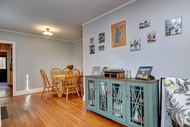 dining space with wood-type flooring and ornamental molding