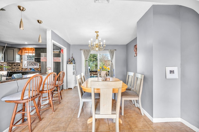 tiled dining room featuring a notable chandelier and sink