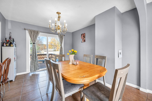 dining area featuring tile patterned floors and an inviting chandelier