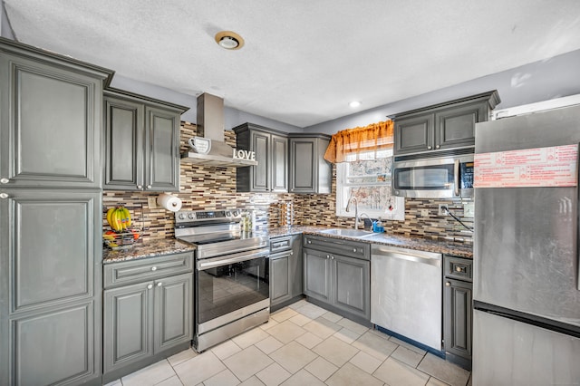 kitchen featuring gray cabinets, appliances with stainless steel finishes, sink, and wall chimney exhaust hood