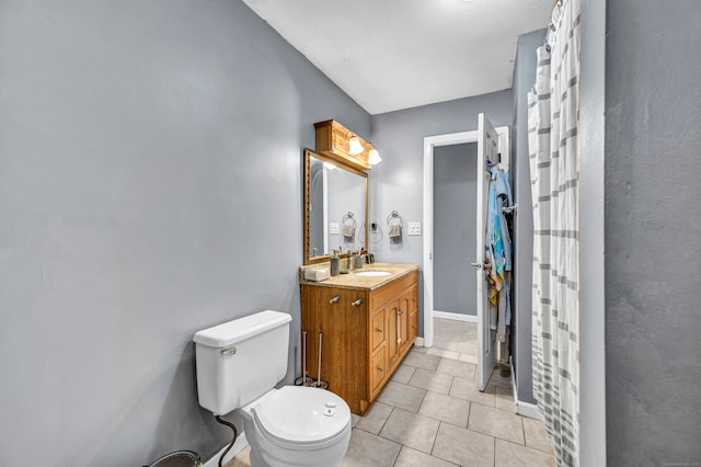 bathroom featuring tile patterned flooring, vanity, and toilet