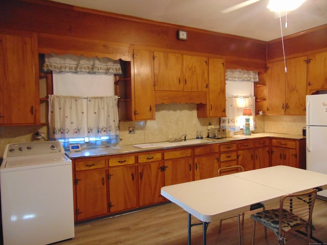 kitchen featuring washer / dryer, light wood-type flooring, white refrigerator, sink, and ceiling fan