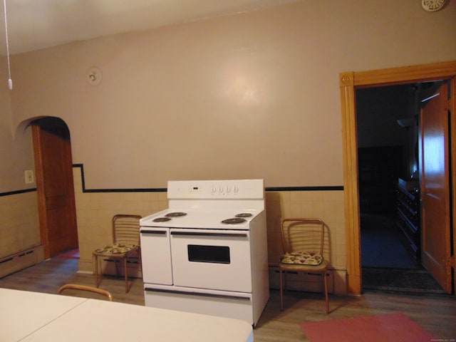 kitchen featuring white electric stove, dark wood-type flooring, and tile walls