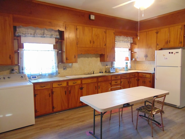 kitchen featuring a wealth of natural light, light hardwood / wood-style floors, white refrigerator, and washer / clothes dryer