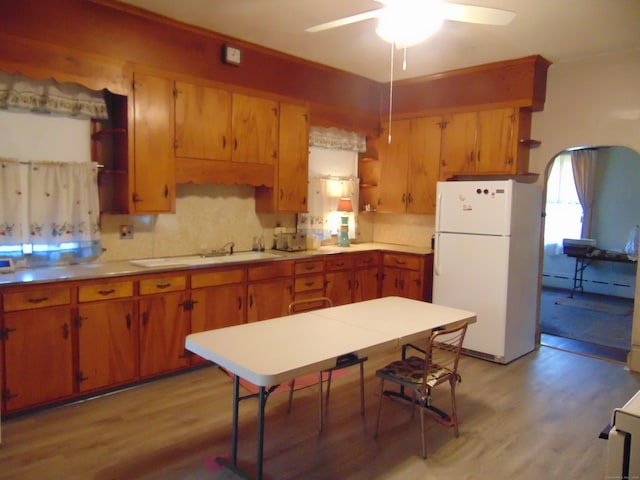 kitchen featuring ceiling fan, light hardwood / wood-style floors, decorative backsplash, and white fridge