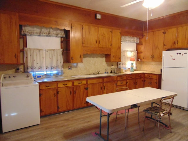 kitchen featuring sink, ceiling fan, white fridge, light wood-type flooring, and washer / clothes dryer