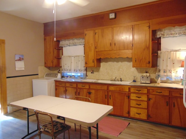 kitchen with light wood-type flooring, ceiling fan, and washer / dryer